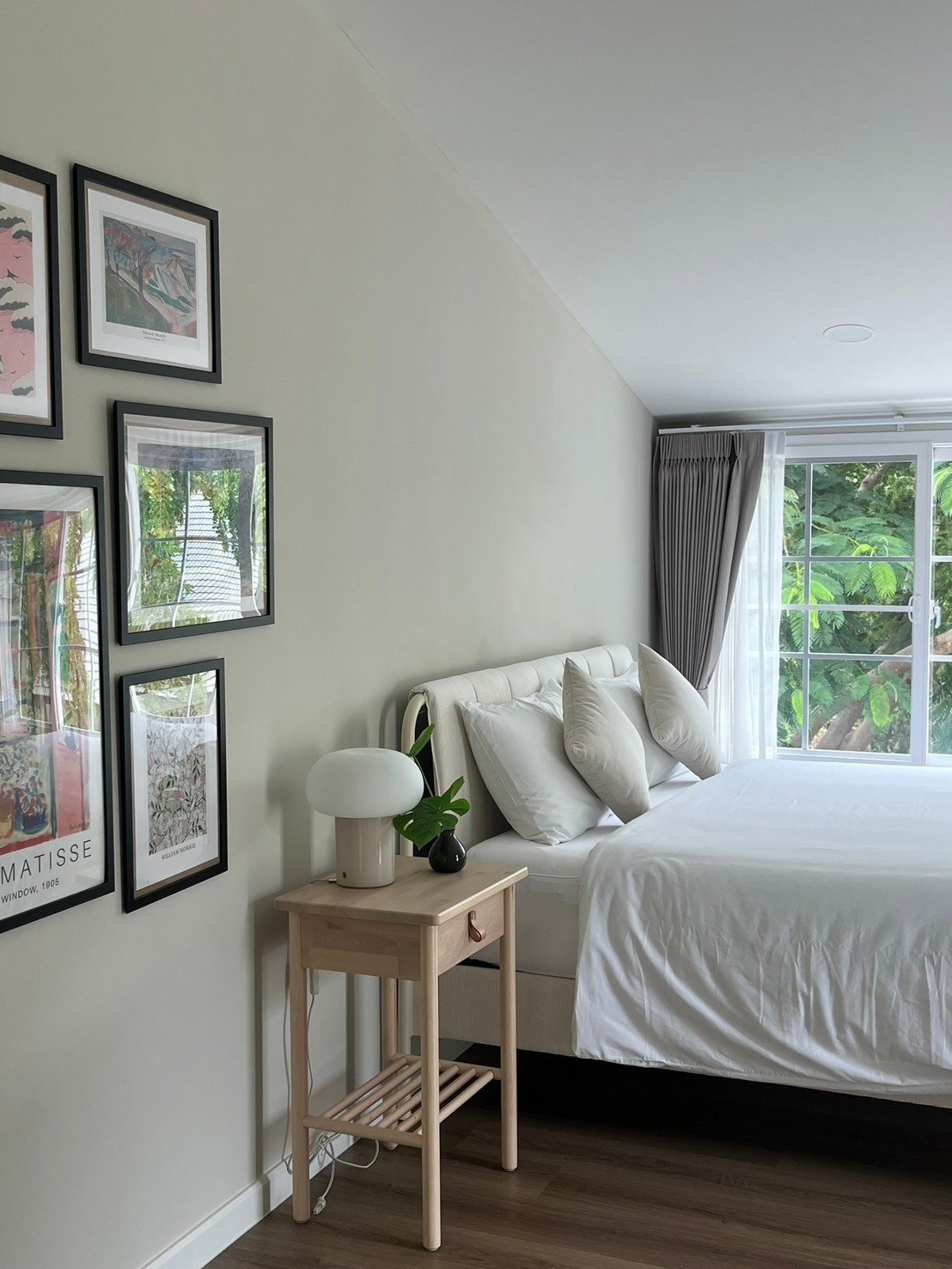 Bedroom under the eaves with print wall and garden window
